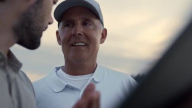 Zengin golfçüler online görüntülü sohbette tablet arıyorlar. Zengin baba oğlu zaman geçiriyor..