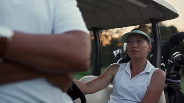 Married couple relax golf activity in golfing driving cart. Two golfers sit car. — Stock Video