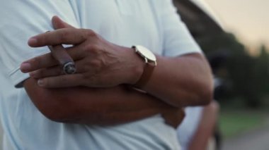 Golf arabasıyla puro içen bir adam. Zengin çift golf arabasında dinleniyor..