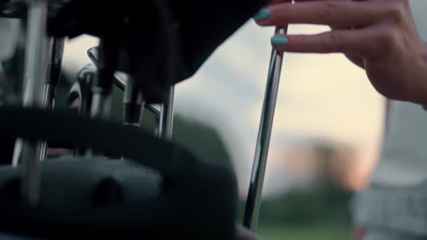Een vrouw die golfclub speelt in een sporttas. Vrouwelijke handen houden putter op koers. — Stockvideo
