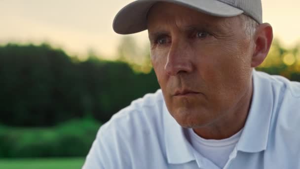 Пенсионер ищет гольф на поле загородного клуба. Окаменелый человек наслаждается закатом. — стоковое видео