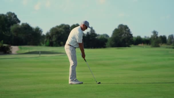 Oude man golft op gras fairway. Pro speler swing club raken bal buiten. — Stockvideo