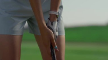 Yeşil sahada golf oynayan aktif bir kadın. Golfçüler el ele tutuşur..