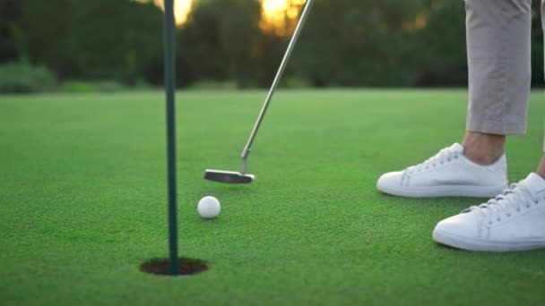Clube de golfe batendo bola em campo verde buraco. Golfe jogador swing teeing putter. — Vídeo de Stock