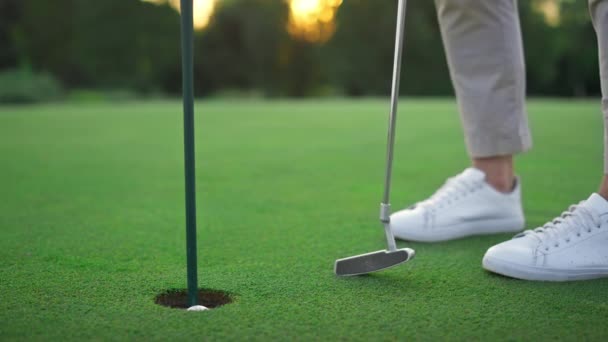 Golfspeler benen ontspannen bij golfbal gat. Golfer poseren op groene weelderige cursus. — Stockvideo