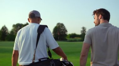 Baba oğul saha kursuna gidiyor. İki golfçü spor ekipmanlarını dışarı çıkarır..