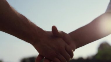 Beyaz insanlar dışarıda el sıkışıyor. İki bilinmeyen iş ortağı yaz mevsiminde başarılı bir anlaşma yaptılar. Gün batımında iki uzman tokalaşıyor. Takım çalışması işbirliği ortaklık kavramı