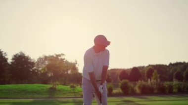 Golf oyuncusunun golf sopası spor antrenmanında. Zengin adam dışarıda lüks bir tatilde eğleniyor. Odaklanmış golfçü, aktif emekliliğin tadını çıkarıyor. Golfçü oyunda topa vuruyor. Varlıklı konsept