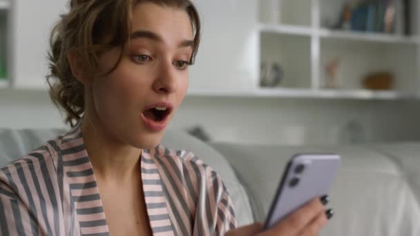 Meglepett Használ Okostelefon Olvasó Üzeneteket Pizsamában Otthon Közelkép Csinos Szőke — Stock videók