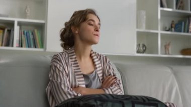 Pijamalı, üzgün kız sorunlarını yakından düşünüyor. Güzel bir bayan hafta sonu kanepeye poz veriyor ve yalnız başına dinleniyor. Evdeki kişisel sorunları göz önüne alan dalgın bir bayan. Kişisel izolasyon kavramı.