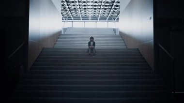 Stresli okul çocuğu karanlık merdivenlerde yalnız kalır. Depresyondaki mutsuz çocuk okul salonunda saklanıyor. Boş koridorda poz veren üzgün çocuk kameraya ciddi bakıyor. Sosyal zorbalık mağduru konsepti.