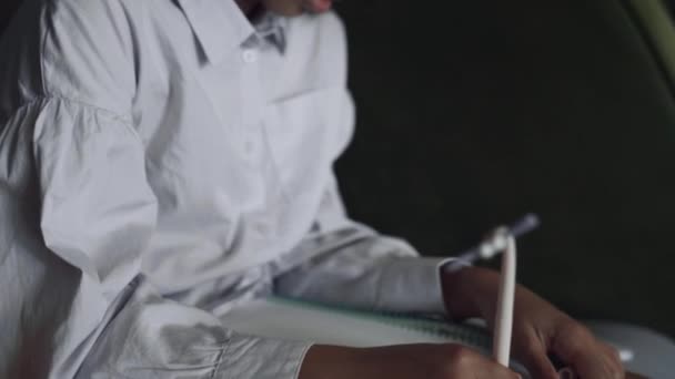 日記にメモを書く集中的な才能の女の子を閉じる アフリカ系アメリカ人の女子高生がベンチに一人で座って面白いペンを持っている スケッチブックで子供の絵を描く前に創造的な宿題 — ストック動画
