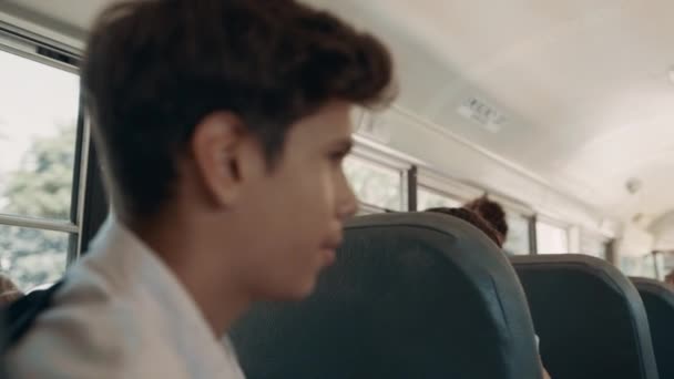 严重的少年男孩说话乘客在校车关闭 印度学生坐在汽车上等着回家 闭关自守的学童看着对话者 传播概念 — 图库视频影像