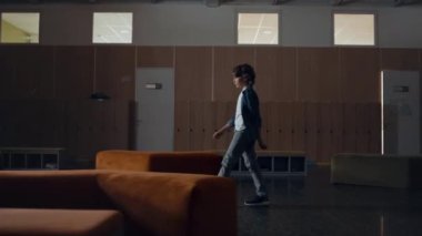 İlkokul çocuğu tek başına boş koridorda yürüyor. Dersleri asan sıkıcı liseli çocuk çıkıyor. Rahat bir çocuk koridordaki ahşap dolapların önünden geçiyor. Tasasız okul hayatı konsepti