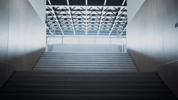 空荡荡的学校楼梯通往大厅 有钢制栏杆的清洁楼梯 阳光照射在宽阔的窗户上 教育机构天花板上的灯 现代建筑概念 — 图库视频影像