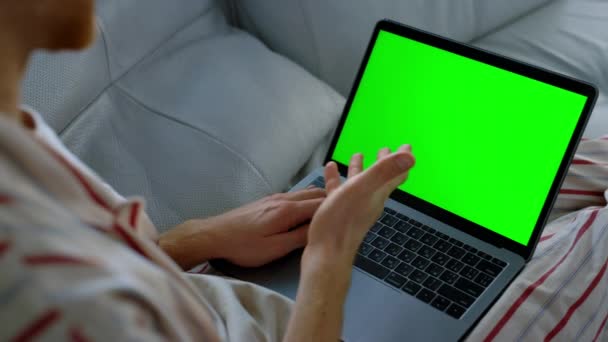 緑のノートパソコンを使用して人を閉じる マネージャーは遠隔地で働いてる 認識されていない男教師モックアップコンピュータ上の仮想会議を持っている 未知のクライアントとチャット上のフリーランサーソファ — ストック動画