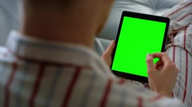İş adamı, yakın plan çekimde tablet aşırıyor. Yeşil ekran şablon cihazı. Bilinmeyen iş adamı kanepede dinleniyor. Krom anahtar diyagramı. Finansal analist hisse senedi haberlerini okuyor pazar verilerini kontrol ediyor