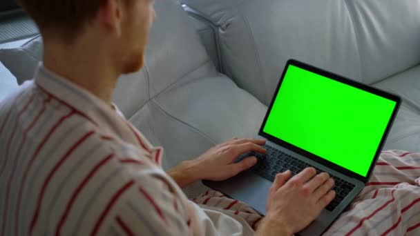 周末特写时 那家伙在讲着色键笔记本电脑 商人有一个虚拟的电话在沙发上休息 自由撰稿人经理在总部的网上会议上挥挥手 不知名的嬉皮士穿着睡衣用绿色电脑 — 图库视频影像