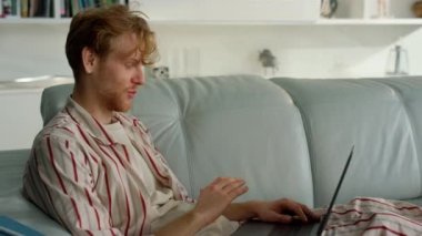 Mutlu adam evde yakın planda sanal buluşmadan bahsediyor. Adam uzak iş yerindeki video konferansının tadını çıkarıyor. Kızıl işadamı öğretmeni çevrimiçi ders veriyor. Freelancer koltukta iş arkadaşıyla sohbet ediyor.