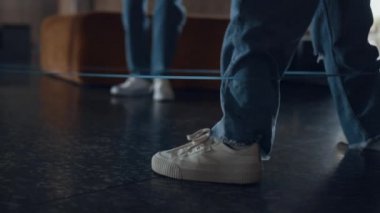 Kapalı bacaklar çocuklar lastik bant oyunu oynuyor. Tatilde elastik tutan tanınmamış neşeli öğrenciler atlıyor. Kot ayakkabı giyen aktif kızlar dersten sonra birlikte eğleniyorlar..