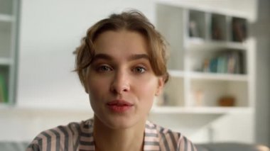 Güzel kız internetten sabah oturma odasında sessiz jest yapıyor. Güzeller güzeli blogcu evde güzellik vlog 'u kaydediyor. Mutlu öğrenci sanal buluşmada fısıldayan haberler hakkında konuşuyor..