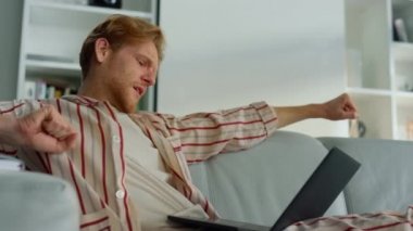 Yorgun bir adam internet sitesine göz atıyor ve ev ofisini kapatıyor. Uykucu yönetici koltukta vücut çalışmasını uzatıyor. Pijamayla dizüstü bilgisayar kullanarak esneyen serbest çalışan bir öğrenci. Tükenmiş kızıl işadamı