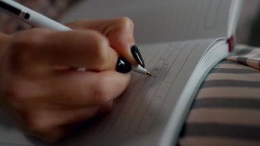 Evdeki not defterine yakın el yazısı. Bilinmeyen öğrenci uzaktan matematik çalışıyor. Bilinmeyen kız serbest çizim defterinde formül denklemi hesaplaması yapıyor. Öğrenci çevrimiçi matematik dersini izliyor.