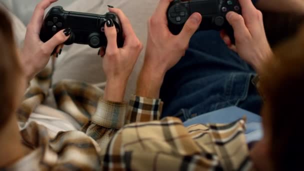 玩家手拿着游戏垫 在家中特写休息 情侣们喜欢电子游戏 使用操纵杆 按下按钮组合的未被认可的学生兴奋的朋友一起玩游戏机 — 图库视频影像