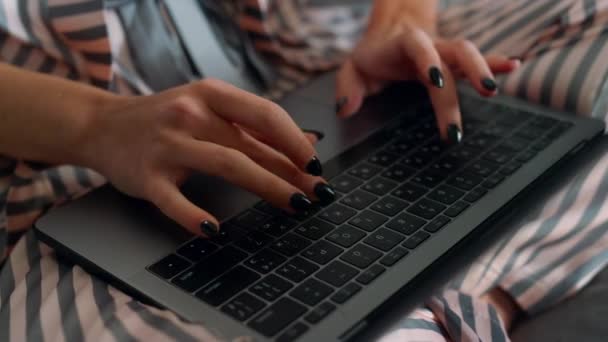 リモートオフィスのクローズアップでノートパソコンを使用してジャーナリストの手 忙しい女の子タイプのキーボードは 週末に大学プロジェクトを準備する 会社のマネージャーは自宅でパジャマで働いています 学生はオンラインで研究を行う — ストック動画