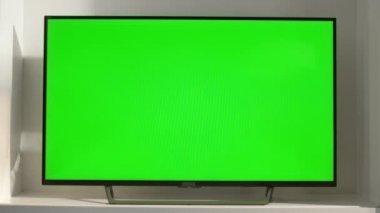 Oturma odasındaki krom anahtarlı akıllı televizyon, yakın plan. Güneş ışığında boş ekranlı aygıt. Evde düz ekran televizyon modeli var. Televizyon programları izleyip, platformlar halinde film izlemek. Hafta sonu boş zaman kavramı.