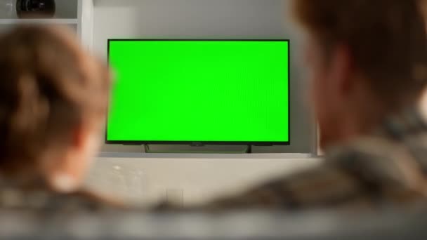 妻子用绿色电视屏幕切换频道 家庭日常观看节目 未被识别的朋友使用遥控选择流媒体平台膜平面屏幕模型 家庭周末休闲 — 图库视频影像