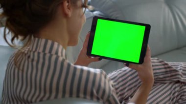 Krom anahtarlı tablet bilgisayarı elinde tutan bir genç. Kız yastık kullanarak kanepede dinleniyor. Tanımlanamayan kadın görüntülü arama dijital bloknotuyla konuşuyor. Salgın karantinasında öğrenci sohbet arkadaşı