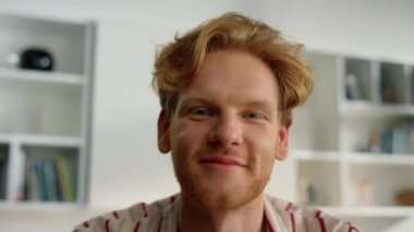 Yakın çekim pozitif adam ailesiyle online sohbet ediyor, gülümseyen kızıl adam web kamerası görüntüsü veriyor. Neşeli serbest öğrenci evdeki blog yayın platformunu izliyor. Mutlu yönetici video konferansında eğleniyor.