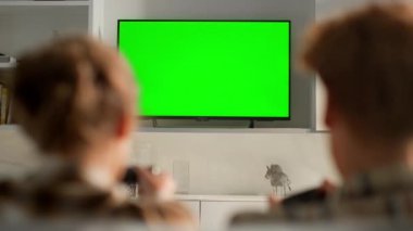 Video oyunları televizyon krom anahtarı oturma odasında. Kimliği belirsiz kadın evdeki online konsol yarışmasında yenilen adamı kutluyor. Oyun oynayan çiftler. Oyun oynayan çiftler. Mockup düz ekran aygıtı