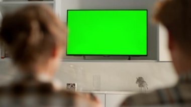 Arkadaşlar evde yeşil ekran video oyunu oynuyorlar. Krom tuşlu düz ekran set. Tanınmayan oyuncular, hafta sonu internet konsol yarışmasının keyfini çıkarıyorlar. Oturma odasında modern model aygıtı