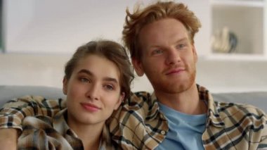 Romantik çift yakın plan film akşamının tadını çıkarır. Sevgi dolu aile kanepesi. Gülümseyen kızıl adam evde güzel kız arkadaşına sarılıyor. Neşeli öğrenciler çevrimiçi blog içeriğini rahat bir yerde izliyorlar. 
