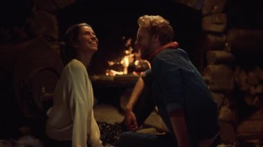 Mutlu çift romantik bir akşamın tadını çıkarsın. Sevgililer şömine köşkünde birlikte gülerler. Neşeli kız arkadaş, kış tatili otelinde konuşmanın keyfini çıkar. Aşk şefkati eğlence konsepti.