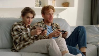 Oyun oynarken joystickleri kaybeden mutlu bir çift. Üzgün oyuncular kanepede dinlenir. Heyecanlı oyuncular çevrimiçi turnuva oyunları hakkında konuşuyor. Kızıl saçlı, güzel bir kadın evde av tüfeği kullanıyor..
