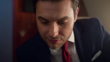 Takım elbise içinde çalışan yakın plan mutlu girişimci. Kendine güvenen iş adamı jeti. Gülümseyen yakışıklı bir adam bilinmeyen bir ortağın anlaşmasını tartışıyor. Zengin başarılı milyoner birinci sınıf yolculukta dinleniyor.