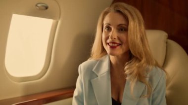 İş ortağı jet kapanışından bahsediyor. Çekici kadın şampanya içerek dinleniyor. Neşeli iş kadını lüks uçaklarda konuşmaktan hoşlanıyor. Gülümseyen sarışın eş, bilinmeyen bir kocayla şirket gezisine çıkıyor.