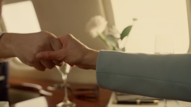 ビジネスパーソンはプライベートジェットで握手をする シャンパンを飲む成功を祝う企業チーム ポールホールで知られていないパートナーと取引をする笑顔のビジネスマン 業績概念 — ストック動画
