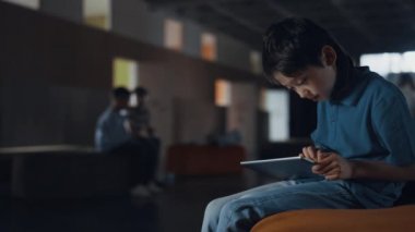 Bağımlı ilkokul öğrencisi okul koridorunda tek başına oturan tablet bilgisayar kullanıyor. Odaklanmış esmer okul çocuğu internette arkadaşlarıyla sohbet ediyor. Ergen çocuk aktif sınıf arkadaşlarını görmezden geliyor. Tatilde eğleniyor.. 