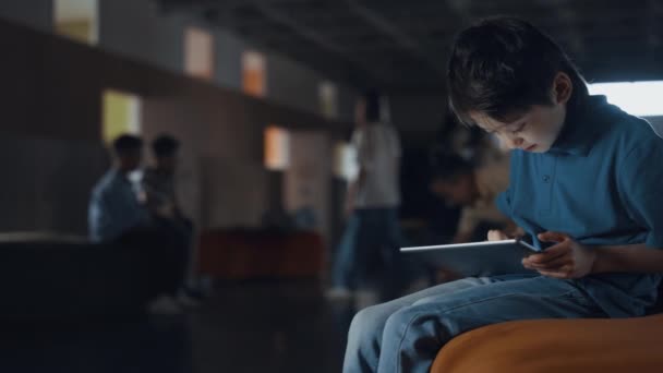 Základní Věkový Chlapec Sedí Sám Drží Tablet Školním Sále Soustředěný — Stock video