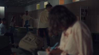 Çizim defterine notlar yazan odaklanmış genç kız canlı okul koridorunu kapatıyor. Yaratıcı liseli kız, dalgalı saçlarıyla yüzünü saklayıp tek başına resim ödevi yapıyor. Öğrenciler teneffüste birlikte eğleniyorlar..