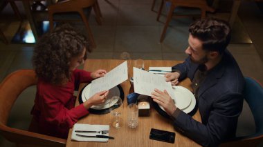 Akşam yemeği randevusunda karışık yarış aşıkları restoran menüsüne bakarlar. Çok ırklı bir çift lüks kafelerde yemek yemeyi tercih ediyor. İki kişi otel barında eğleniyor. Romantik zaman kavramı.