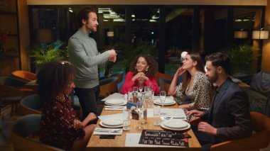 Yetişkinler gurubu, masada restoran toplantısının tadını çıkarıyor. Çatı katındaki kafe masasında arkadaşça sohbet ediyoruz. İnsanlar şatafatlı parti kutlamalarında şampanya şişesi açıyor. Güzel yemek keyfi konsepti..