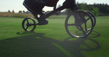 Golf oyuncusu golf arabası kullanıyor. Golfçü bacakları yürürken spor malzemelerini dışarı çıkar. Meçhul profesyonel koç golf kulübüne gidiyor. Lüks tatil zenginler konsepti.