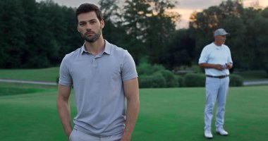 Kendine güvenen bir adam golf sahasının dışında duruyor. İki golfçü gün batımında rahatlar. Sahada kameraya poz veren yakışıklı sporcu modeli. Şehir kulübü üyeleri doğanın tadını çıkarıyor. Etkin golf kavramı