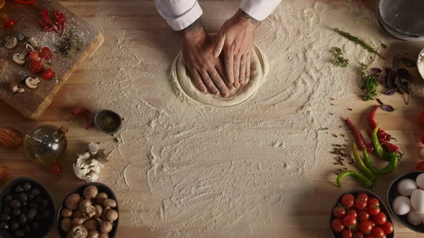 Pastry cook hands kneading raw bread on restaurant cutting board in flour. Unrecognizable bakery chef man cooking preparing italian pizza dough. Close up baker making food in kitchen. Tasty concept.