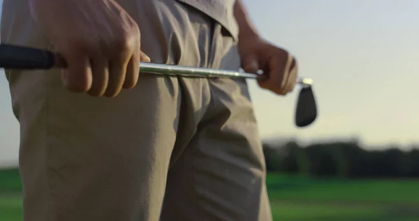 日没のフィールドにゴルフ選手スイングクラブパター ゴルファーはスポーツゲームに重点を置いている 認識できない男の手コースフェアウェイにゴルフ機器を保持 高級趣味豊かなライフスタイル活動のコンセプト — ストック写真